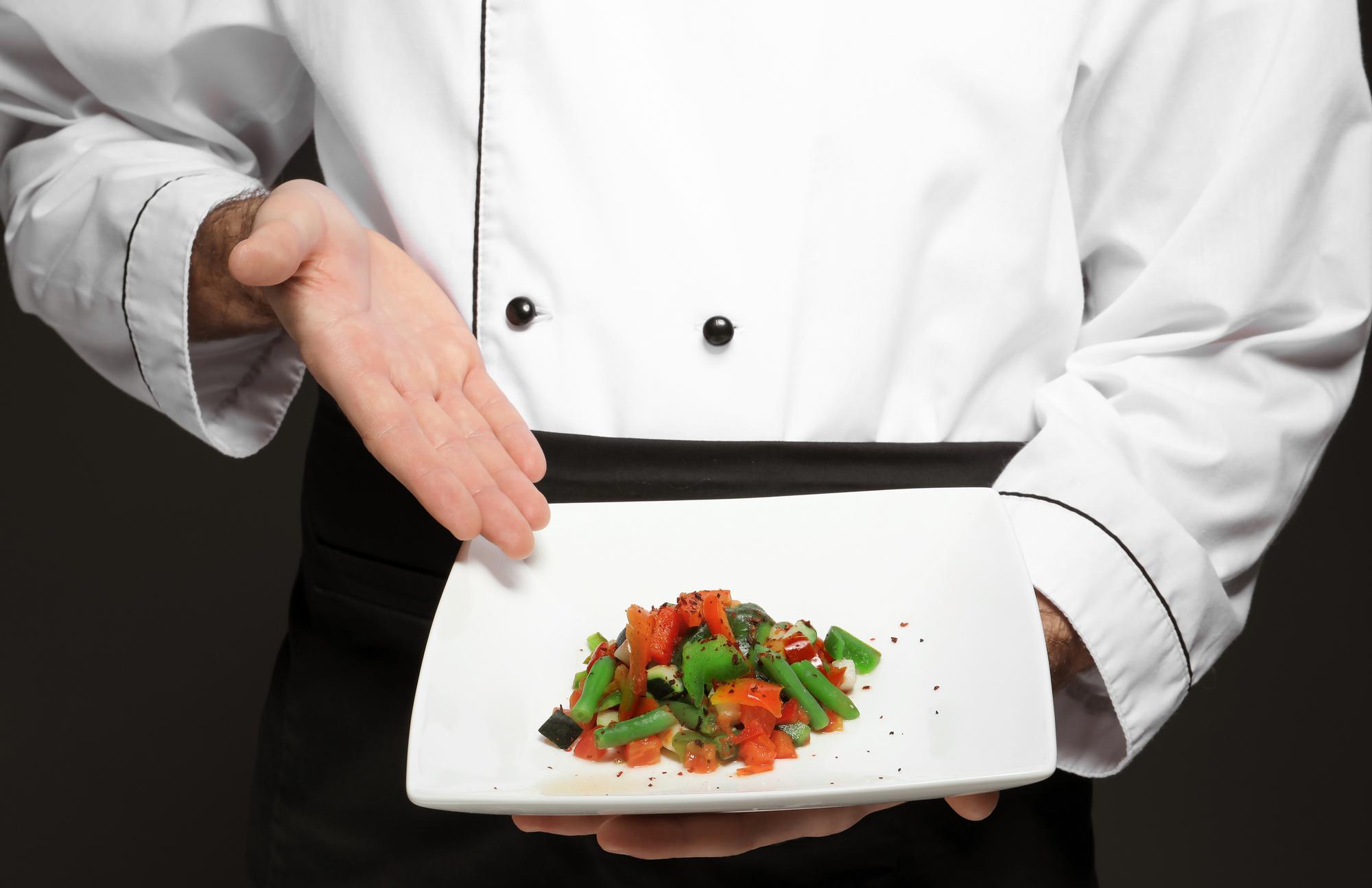 Chef presenting a plated dish in private dining setting
